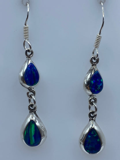 Aretes de ópalo azul sobre escala métrica mostrando largo de 4.2 cm