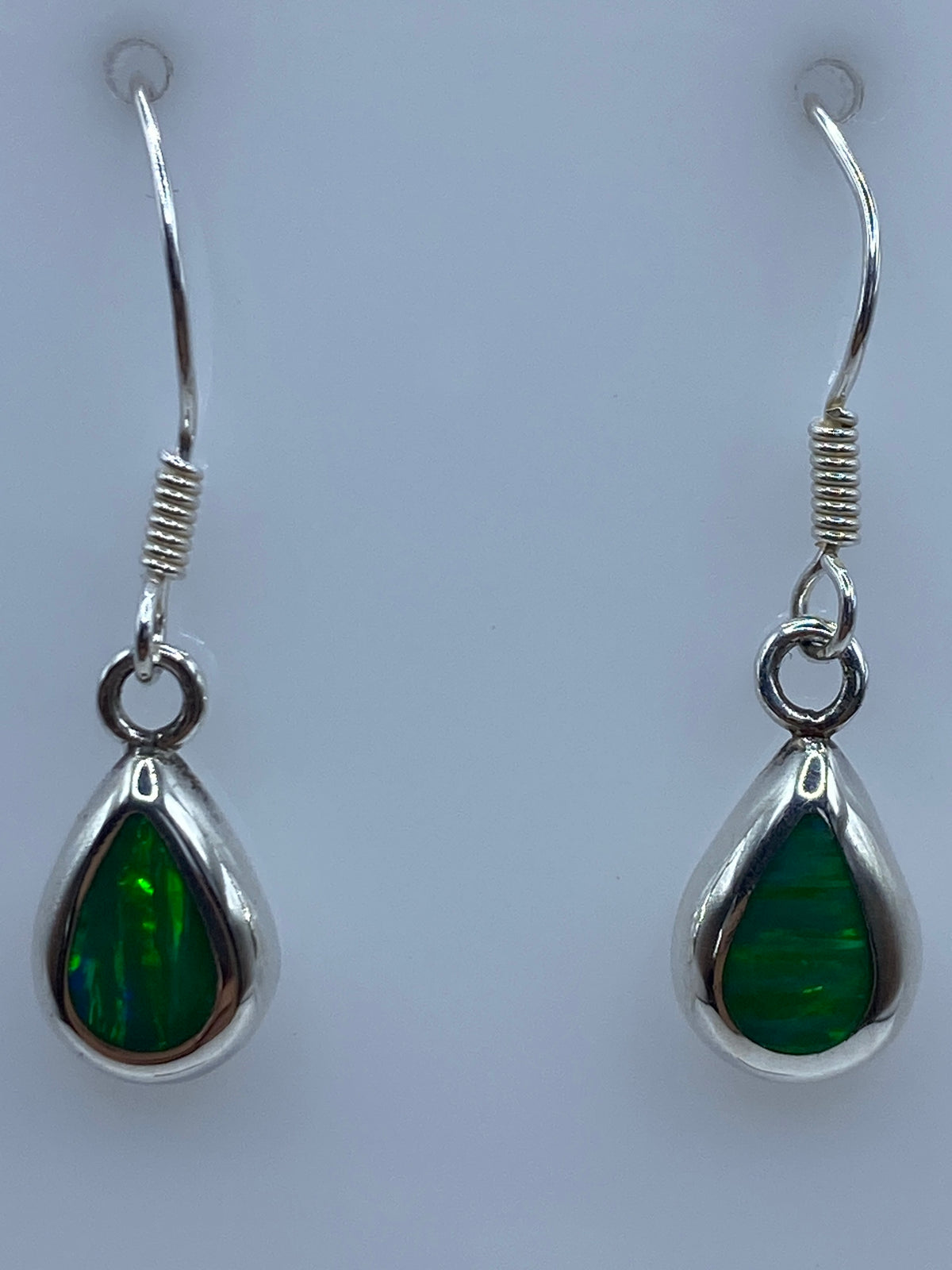 Detalle del opalo de fuego verde con brillo interior en el engaste de plata 925