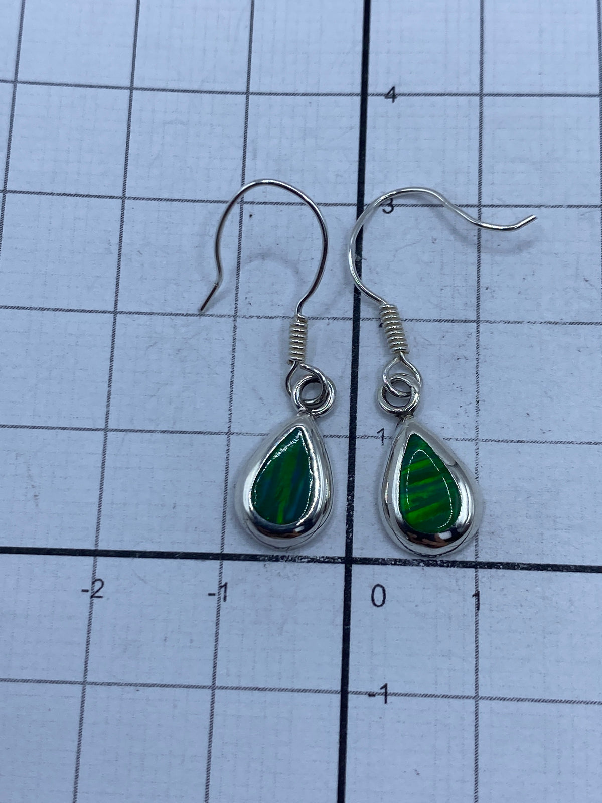 Aretes sobre regla de medida mostrando 3.1 cm de largo y sello 925