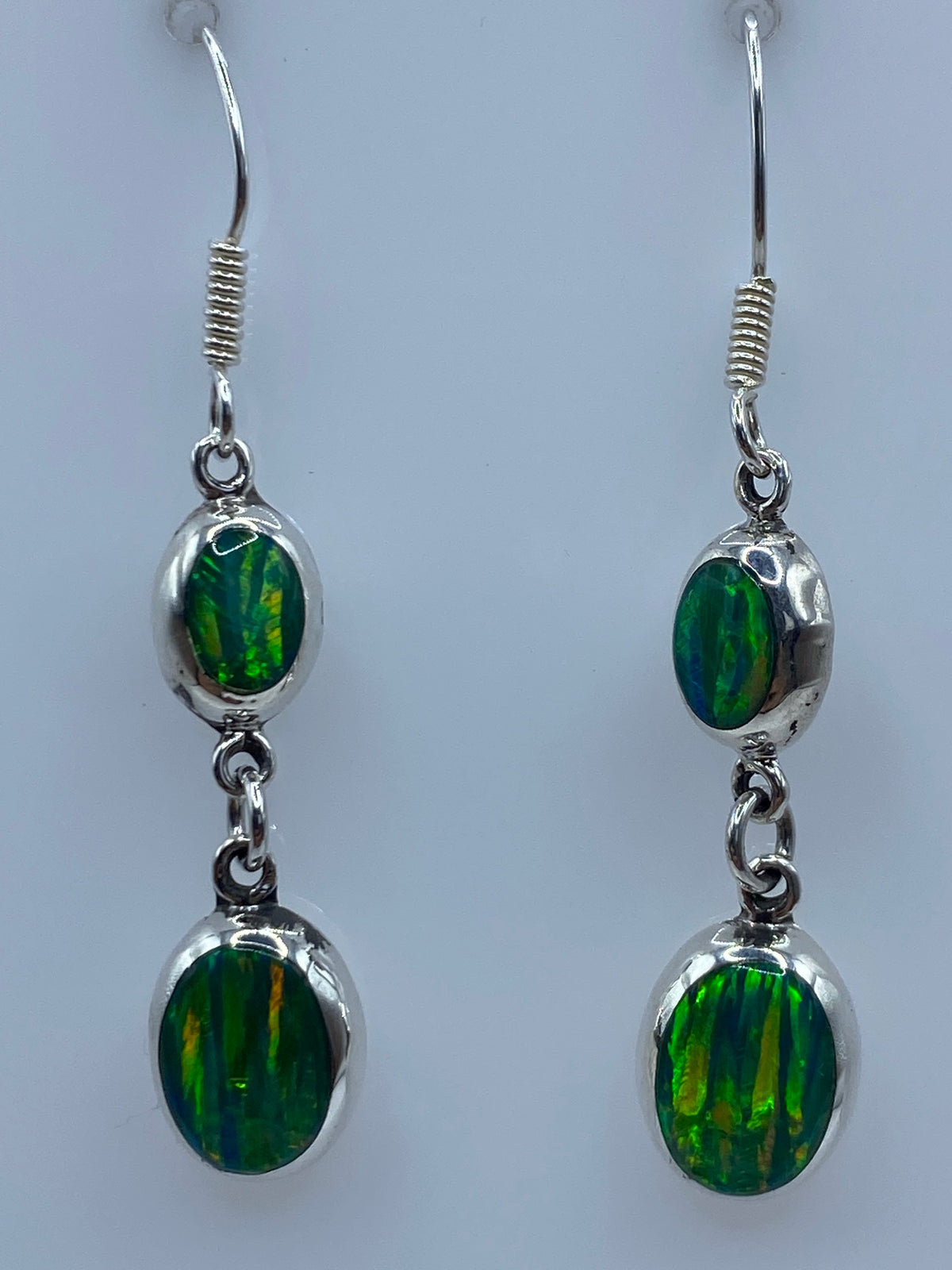 Par de aretes de plata con ópalo de fuego verde limón engastado, colgando de ganchos de plata 925