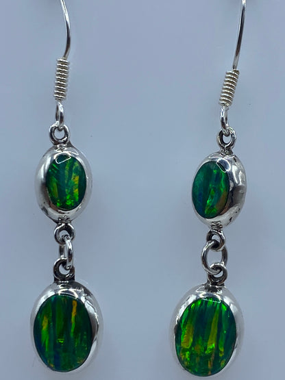 Aretes de 4.5 cm de largo vistos de frente mostrando el color verde limón del ópalo