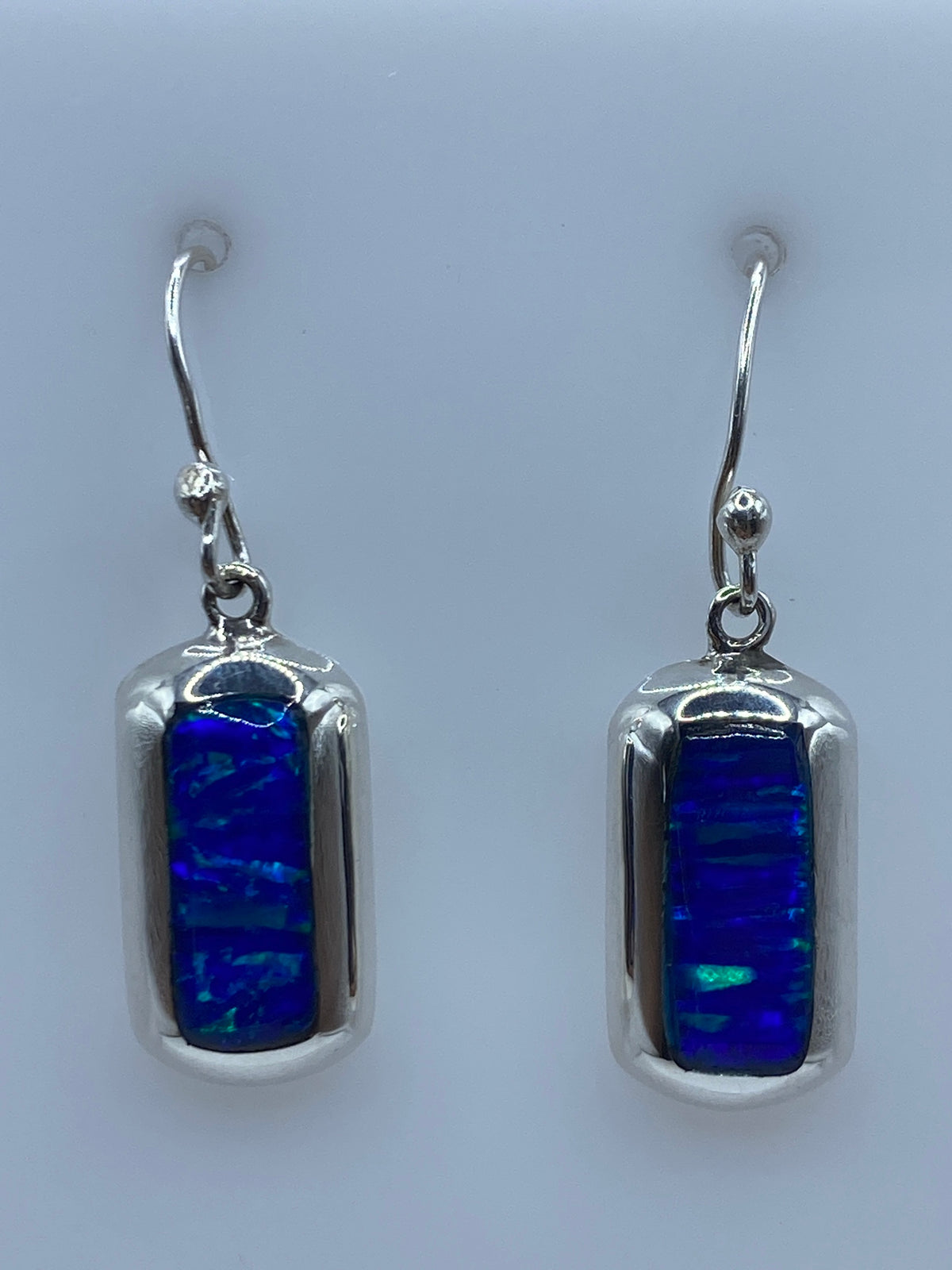 Par de aretes de plata 925 con ópalo de fuego azul, gancho plateado, sobre fondo gris