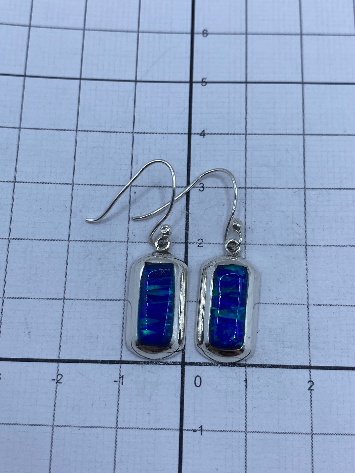 Reverso de los aretes de plata mostrando el Quinto 925 y acabado mate interior