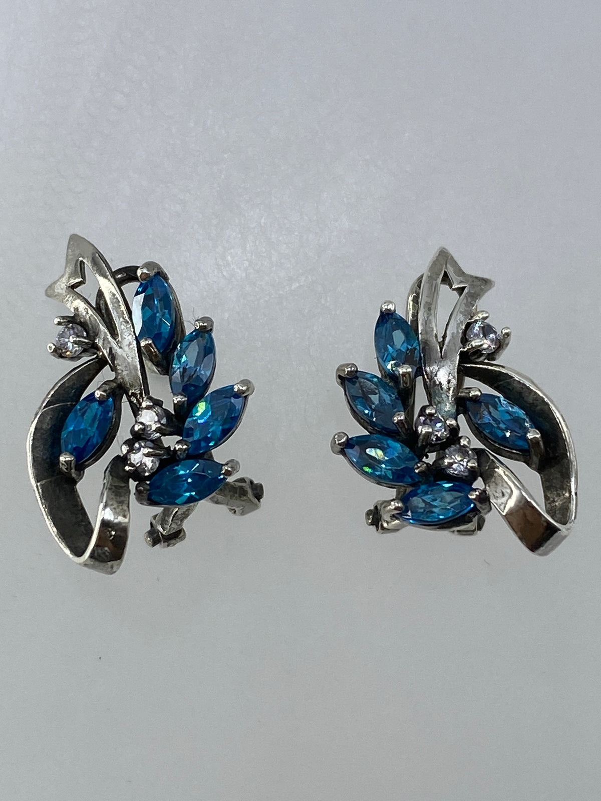 Aretes de 1.7 cm sobre papel milimetrado para referencia de tamaño
