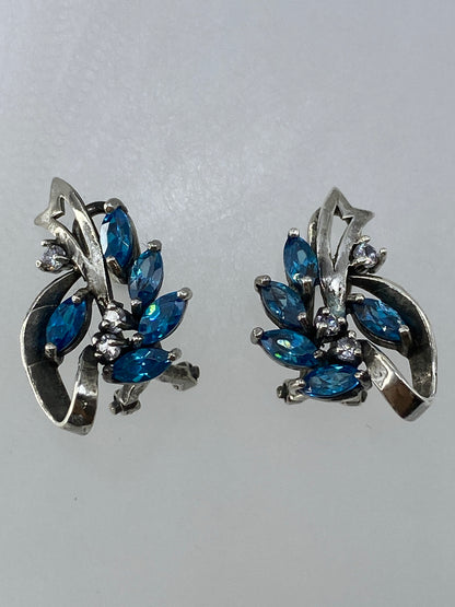 Aretes de 1.7 cm sobre papel milimetrado para referencia de tamaño