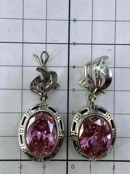 Cercanos los dos aretes de Taxco con reflejo de luz en la circonia rosa