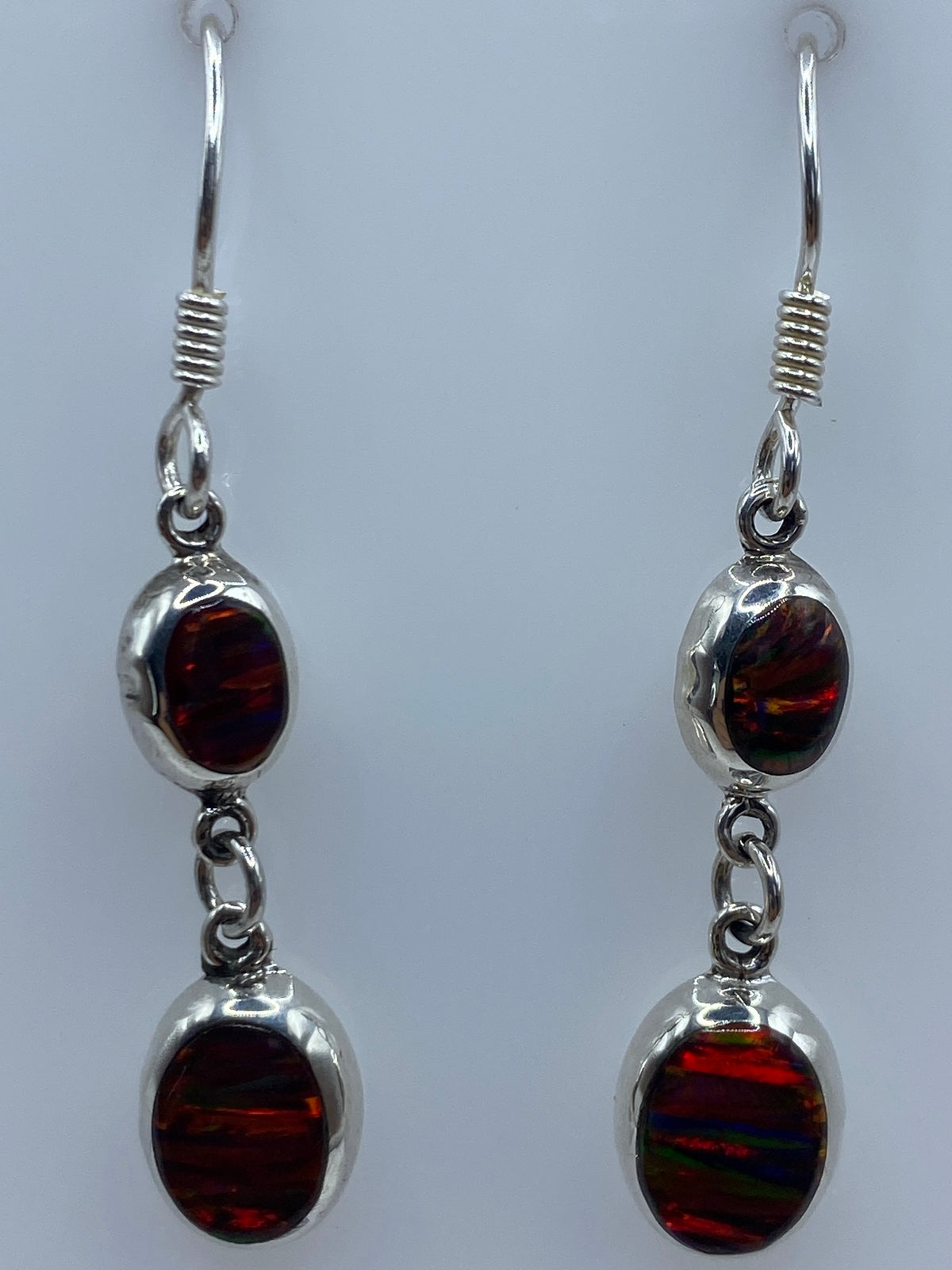 Aretes puestos en la oreja mostrando el juego de luz y color del ópalo
