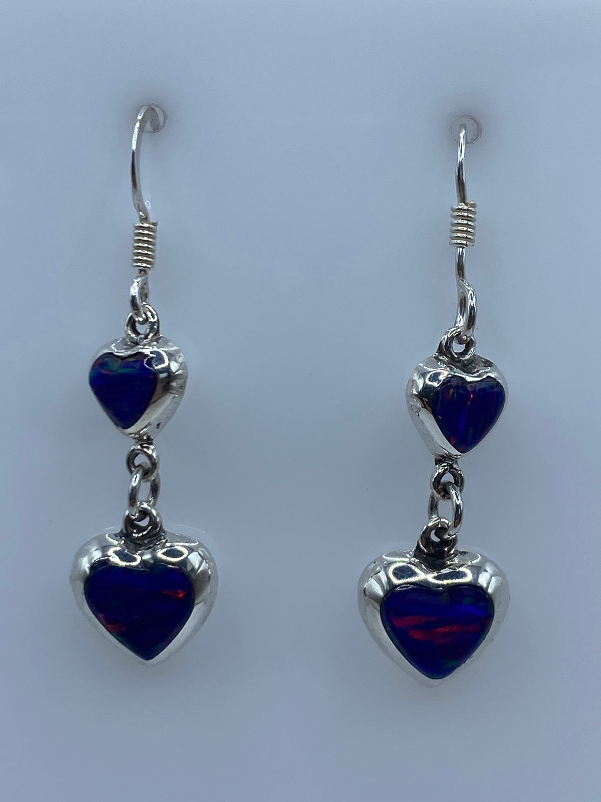 Par de aretes de plata con ópalo de fuego azul de 4 cm en fondo blanco
