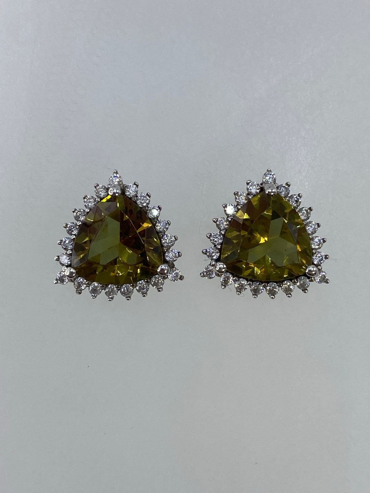 Par de aretes de plata con circonia verde olivo en diseño escultural de corona con puas