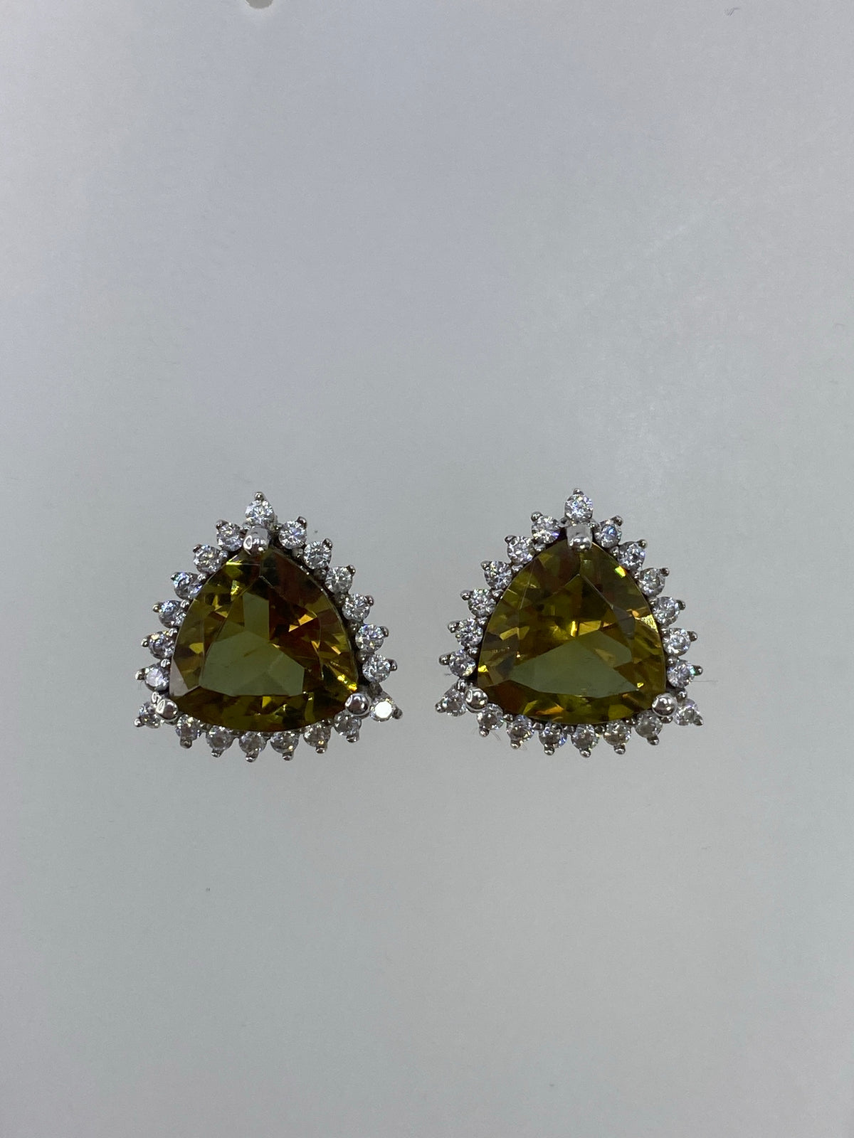 Detalle frontal de un arete mostrando la circonia verde olivo engastada en la corona de plata