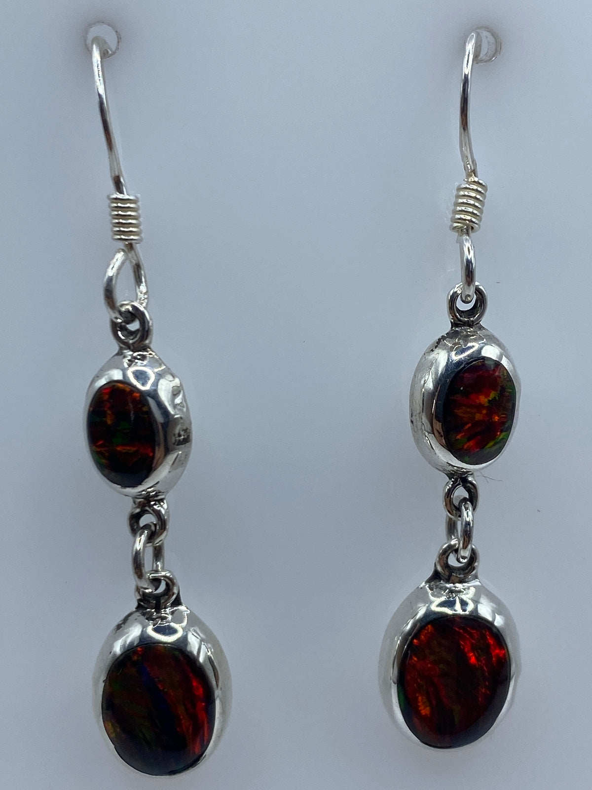 Aretes largos de plata con ópalo sobre fondo blanco mostrando el largo de 4.3 cm