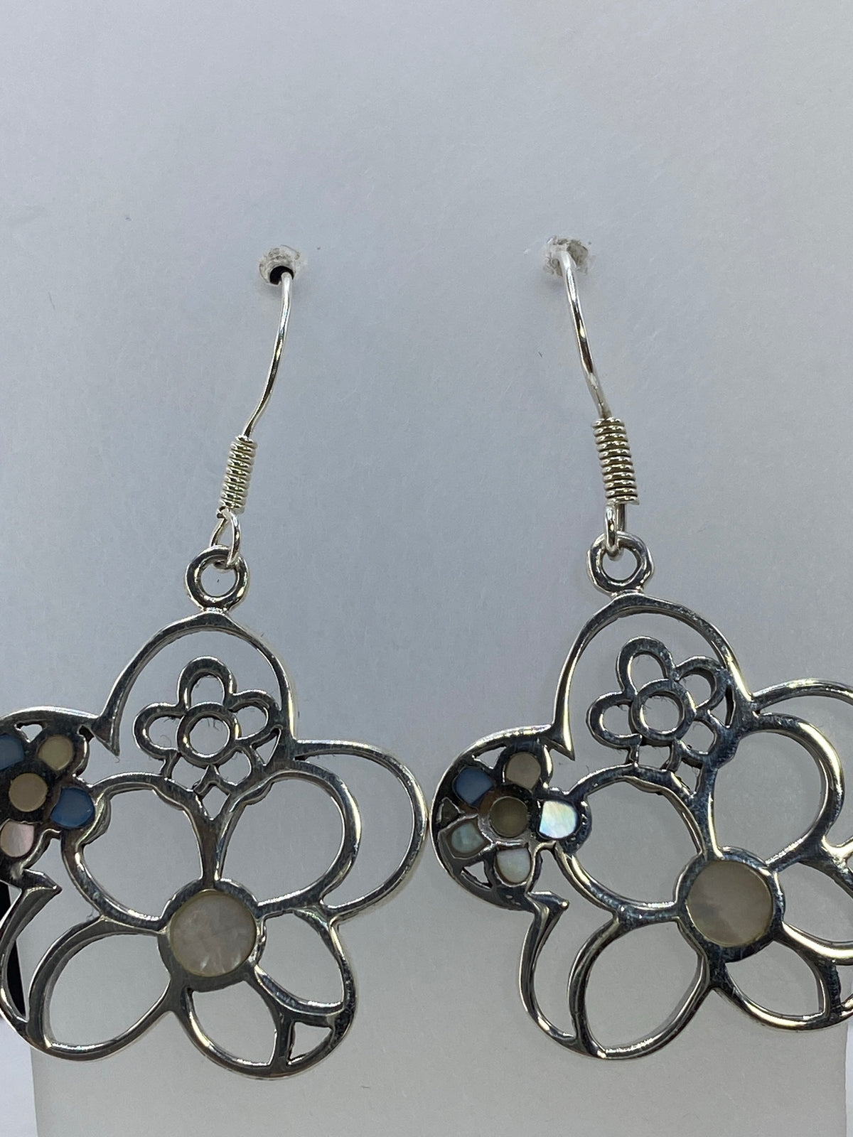 Vista frontal de los aretes floral es: diseño de pétalos abiertos con relieve y brillo