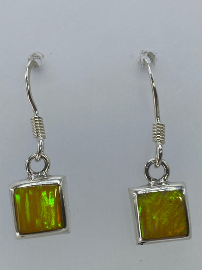 Aretes de ópalo fuego amarillo vistos de cerca mostrando el brillo de la piedra
