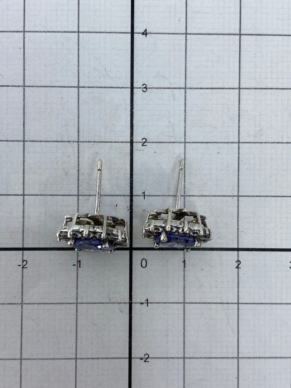Aretes de circonia azul brillante sobre fondo gris