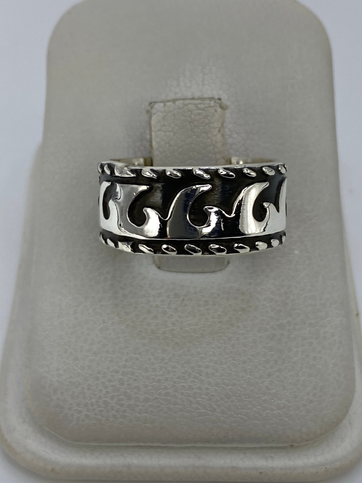 Anillo de plata repujado con relieve floral en la mano de una persona