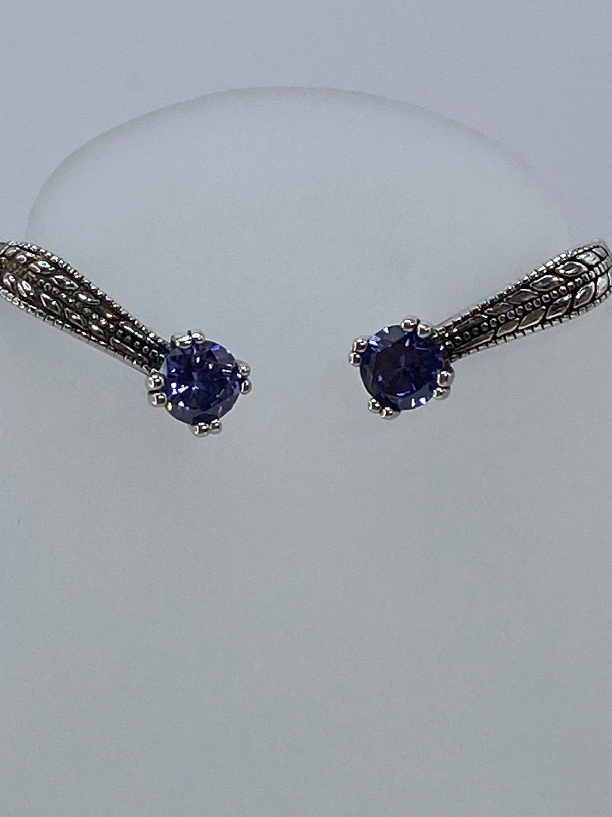 Par de aretes de plata 925 con circonia azul engastada, sobre fondo gris