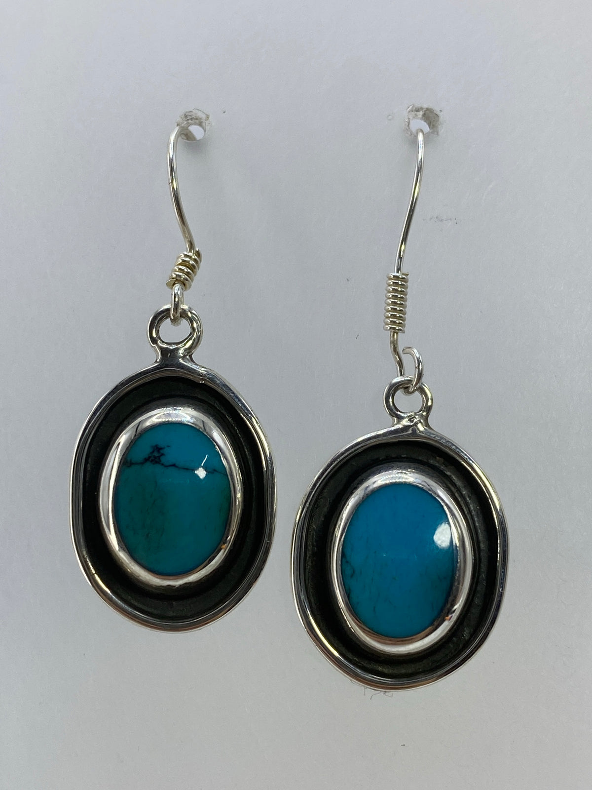 Par de aretes de plata con turquesa azul cielo engastada, marco ovalado plateado