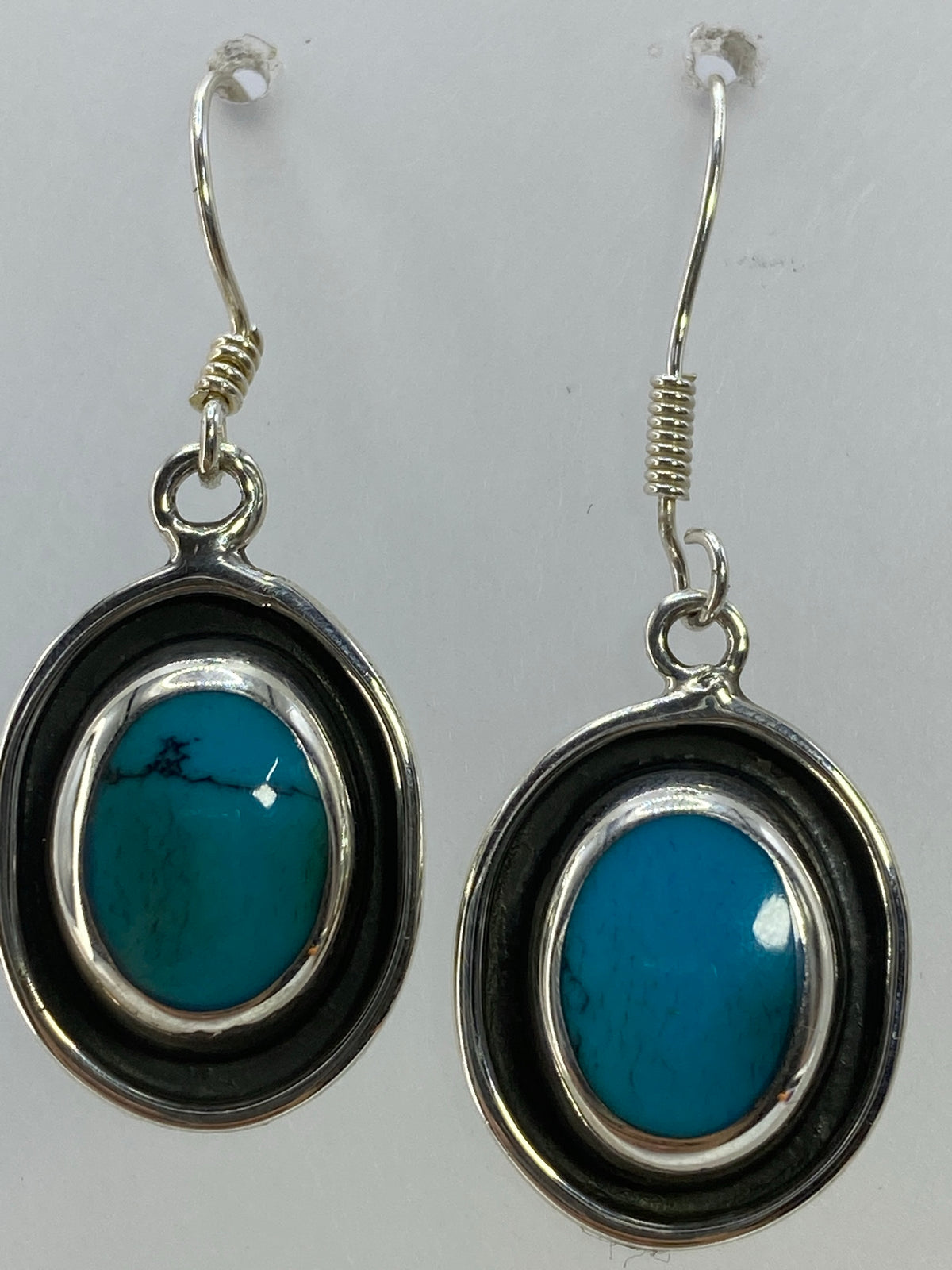 Aretes de turquesa puestos, mostrando el tamaño de 3.5 cm y el brillo azul cielo