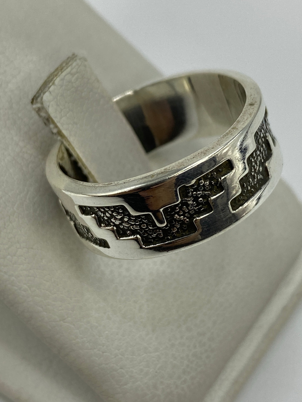 Anillo de plata 925 repujado sobre fondo blanco mostrando el Quinto