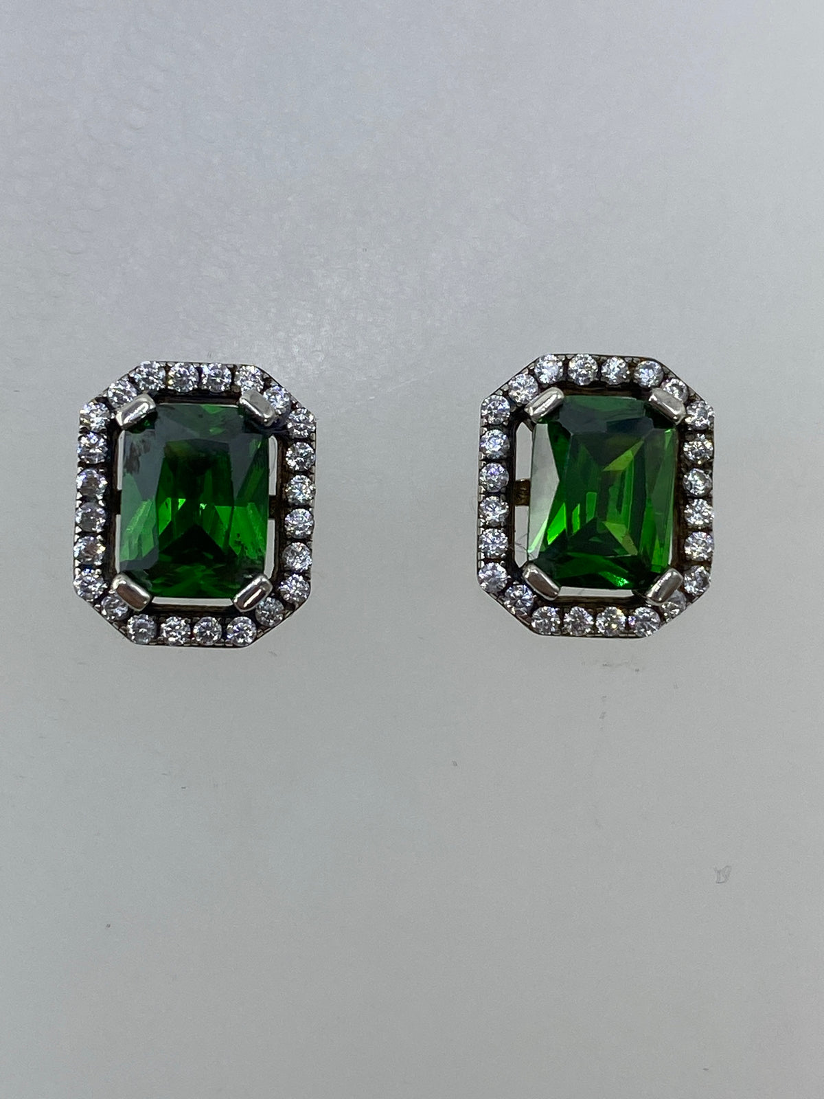 Par de aretes de plata 925 con circonia verde brillante en fondo blanco