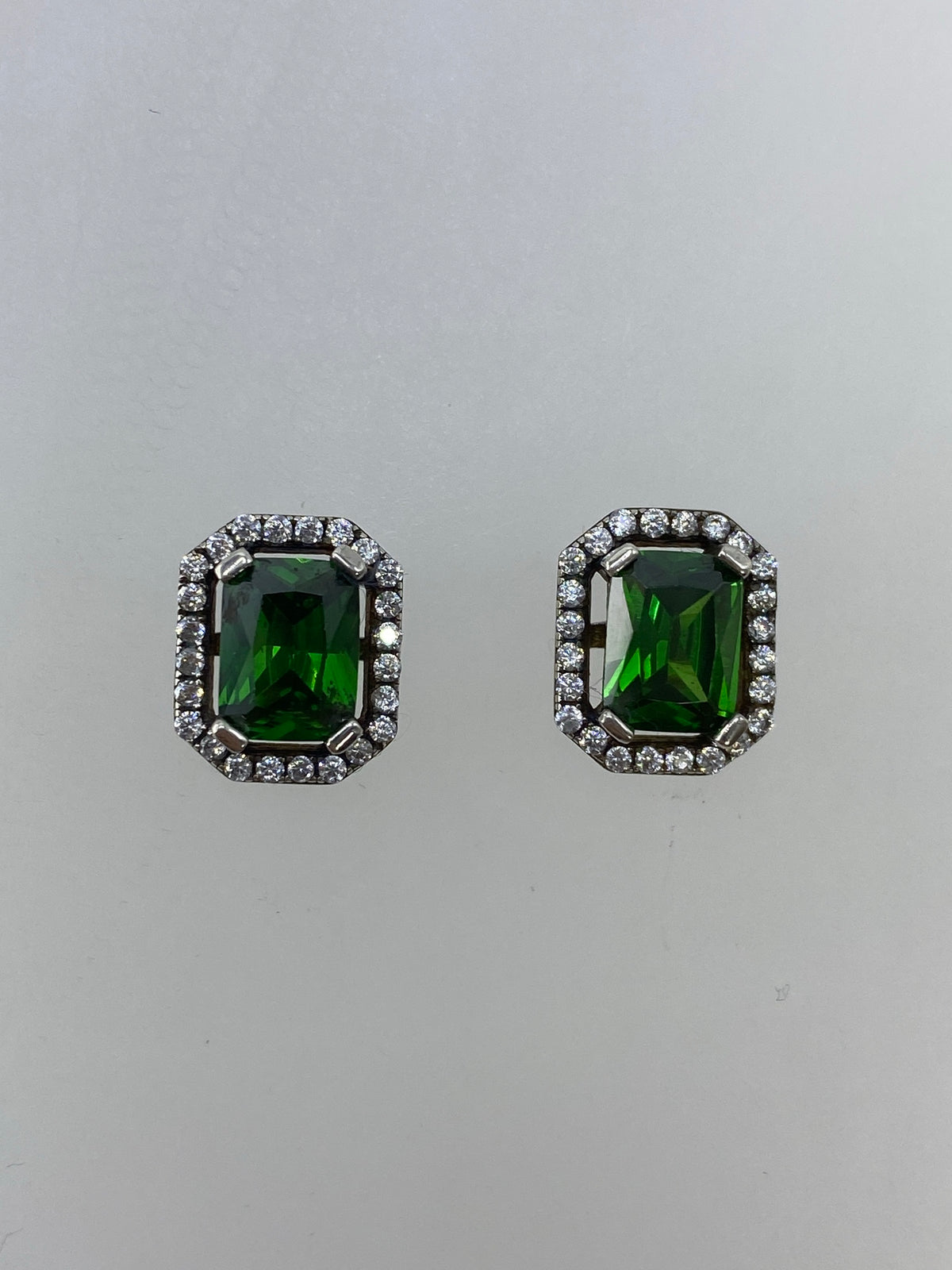 Vista frontal de los aretes de circonia verde engastados en plata, lado a lado