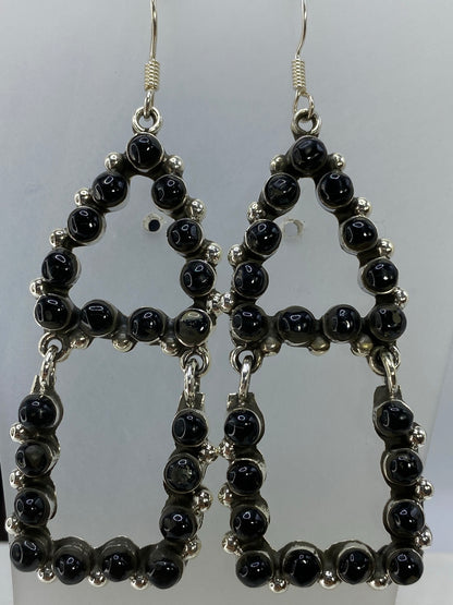 Aretes de onix y plata Taxco colgando, mostrando la elegancia del largo de 7 cm