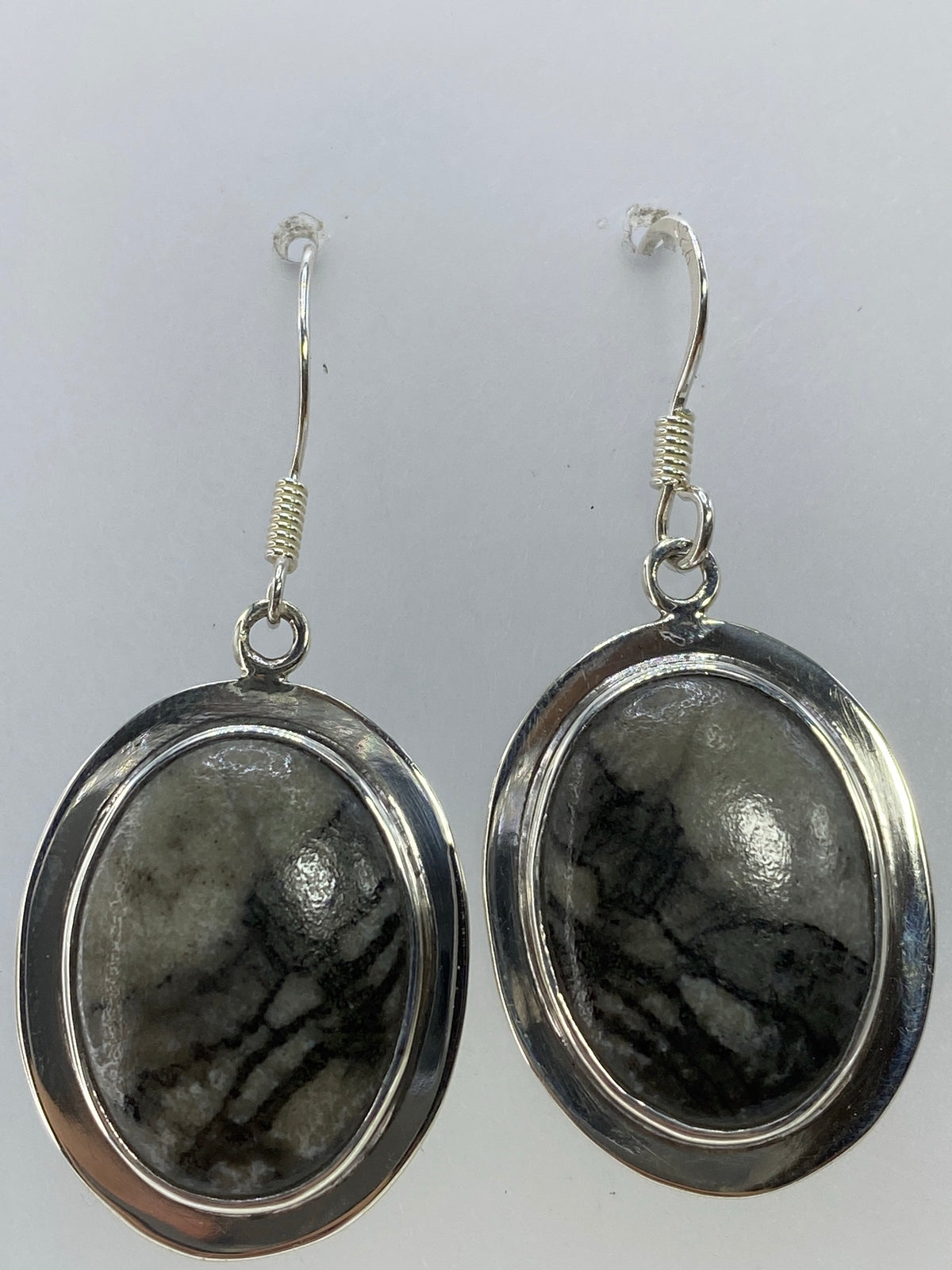 Par de aretes de plata 925 con piedra multicolor, largos 4.2 cm, colgando sobre fondo blanco