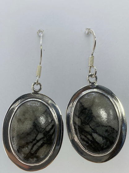 Par de aretes de plata 925 con piedra multicolor, largos 4.2 cm, colgando sobre fondo blanco
