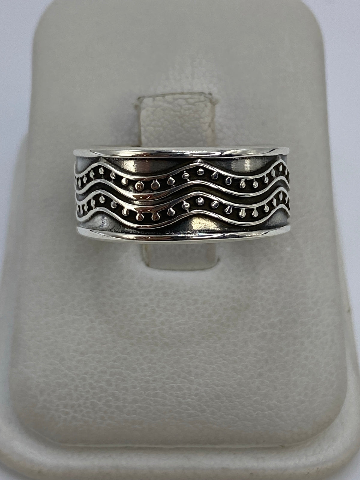 Anillo de plata repujado ondulado con dos bandas de relieve martillado sobre fondo blanco