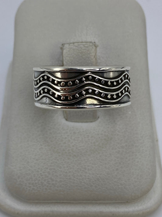 Anillo de plata repujado ondulado con dos bandas de relieve martillado sobre fondo blanco