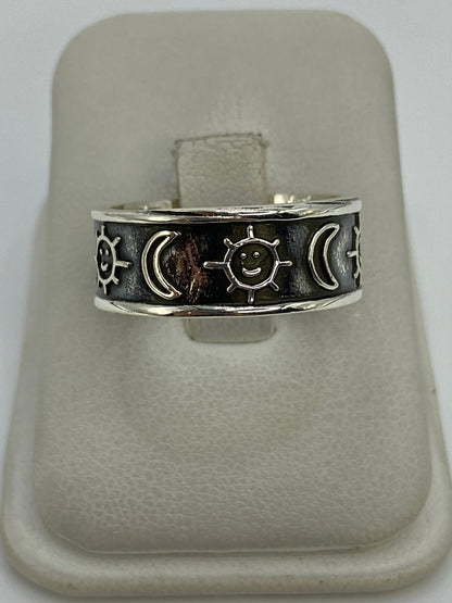 Anillo de plata 925 repujado con sol, lunas y estrellas en relieve, sobre anillo de presentación blanco