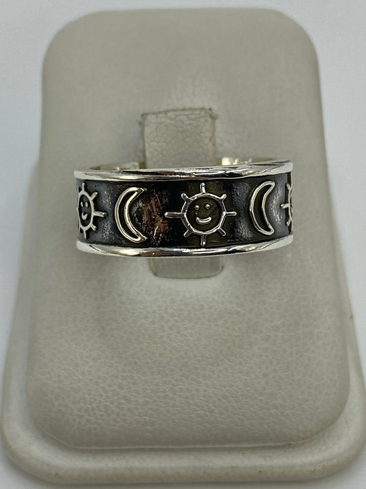 Anillo de plata 925 repujado con sol, lunas y estrellas en relieve, sobre anillo de presentación blanco