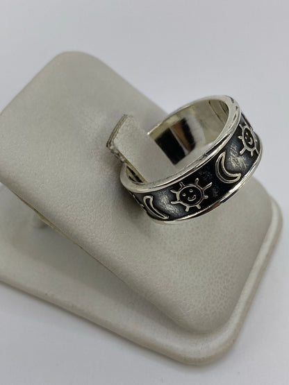 Anillo de repujado desde un lado mostrando el contraste entre el metal pulido y la patina oscura de los relieves