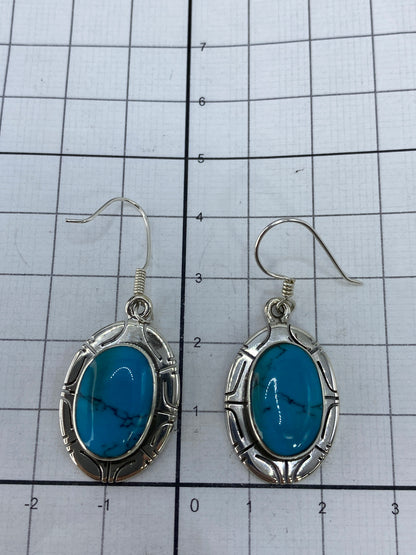 Reverso de los aretes mostrando el Quinto 925 y el trabajo de incrustación artesanal