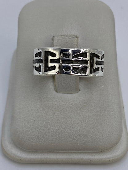 Anillo de plata 925 con diseño geométrico en relieve repujado, visto desde arriba en mano