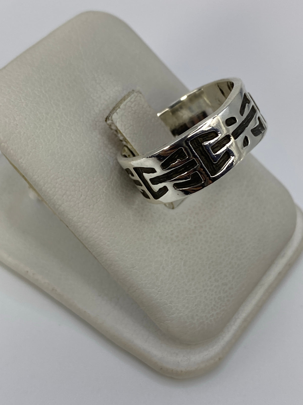Anillo de plata repujado mostrando el patrón geométrico abstracto en detalle