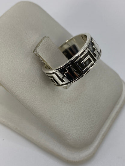 Detalle del anillo repujado mostrando las grecas profundas y el acabado brillante