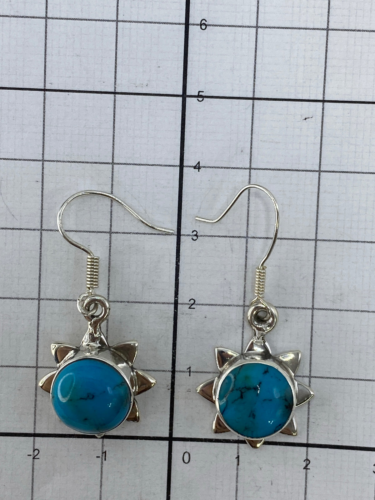 Aretes en la mano mostrando el tamaño de 3.5 cm y el brillo de la turquesa
