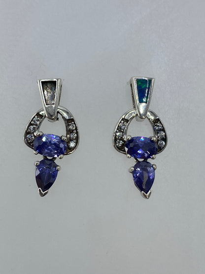 Aretes de plata 925 con circonia morada en par, frente a fondo blanco