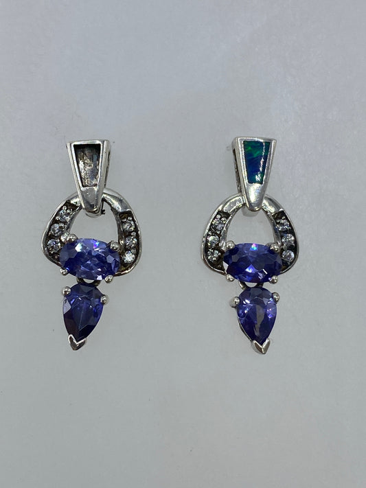 Aretes de plata 925 con circonia morada en par, frente a fondo blanco