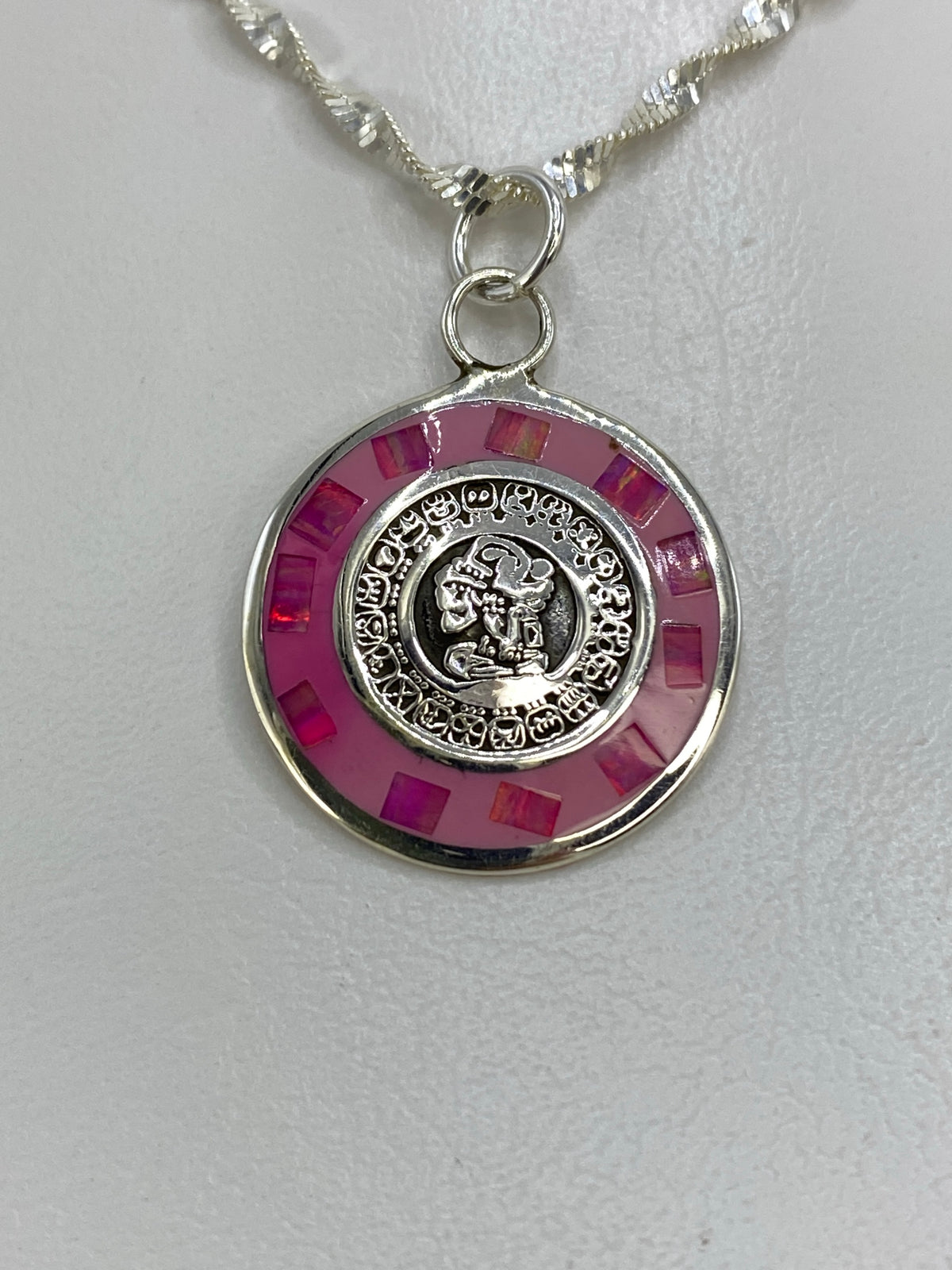 Detalle del calendario prehispánico tallado en plata 925 con piedra rosa