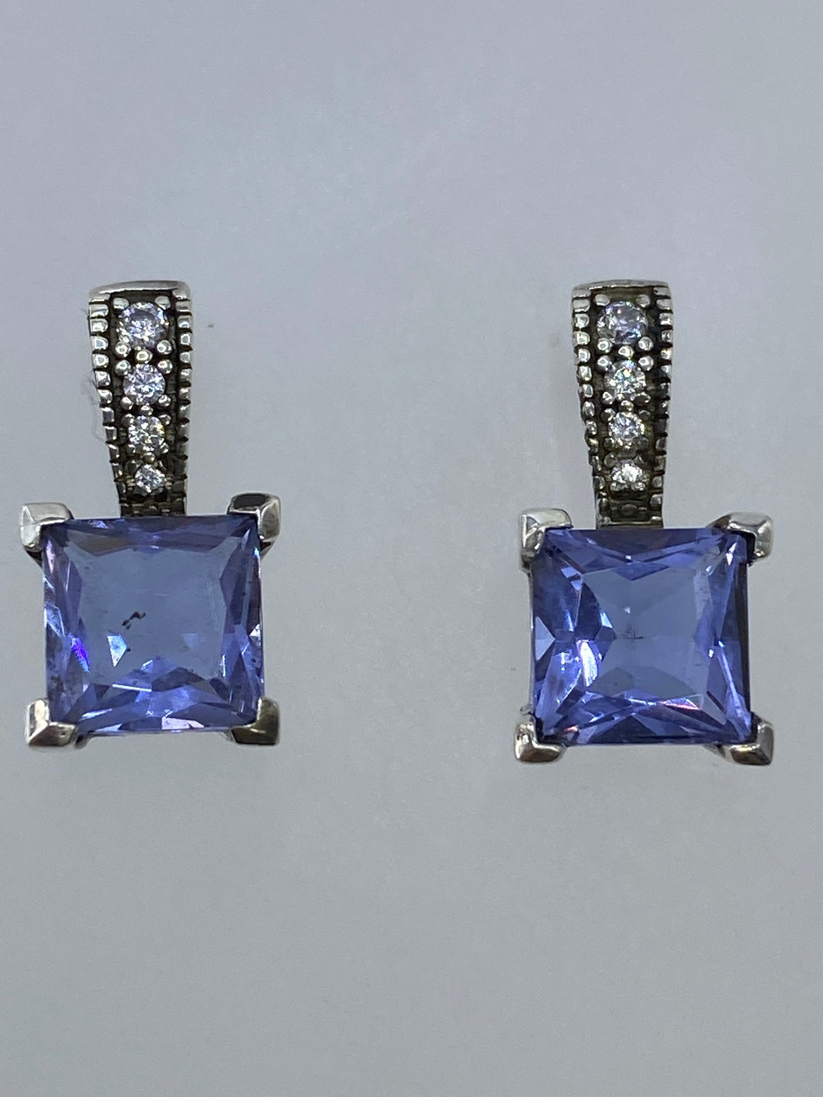 Aretes en la mano mostrando el tamaño compacto de 1.8 cm