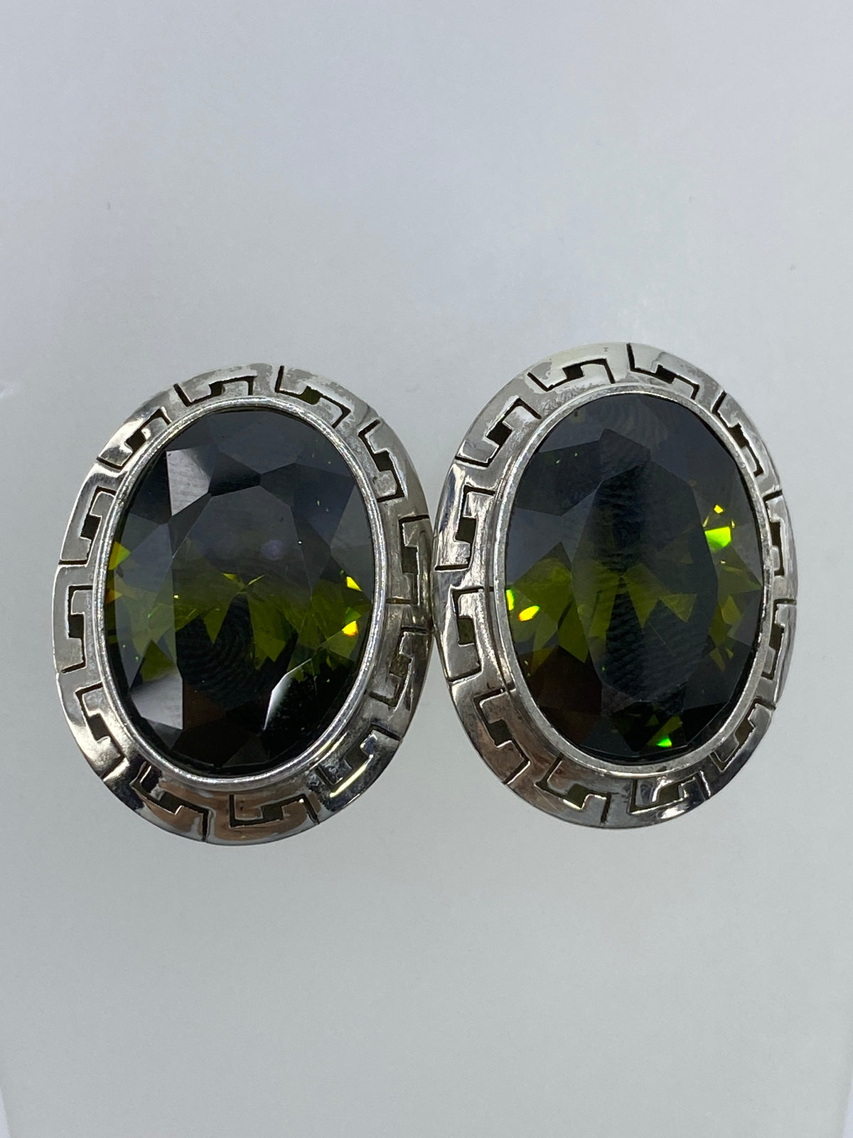 Par de aretes de plata con circonia verde olivo y diseño prehispánico geométrico