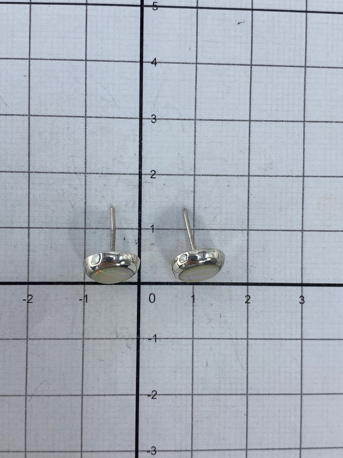 Aretes con postes de plata en fondo blanco mostrando el Quinto 925