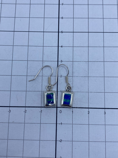 Aretes de plata con ópalo de fuego, mostrando el Quinto 925 grabado