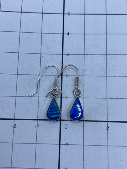 Aretes de plata pura con brillo del ópalo bajo luz natural