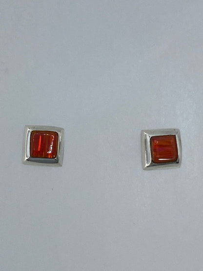 Detalle del engaste a mano del ópalo de fuego en los aretes de plata