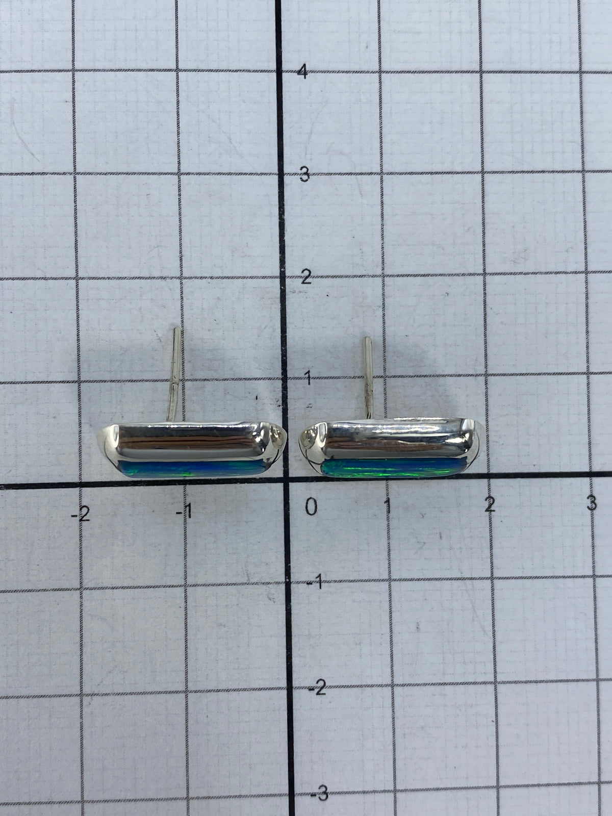 Aretes de ópalo de fuego junto a escala de medidas — 1.5 cm de largo