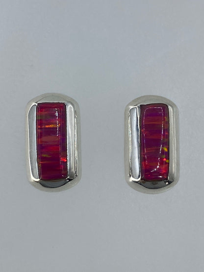Detalle de los aretes mostrando el fuego del ópalo: tonos ámbar, rojo y verde