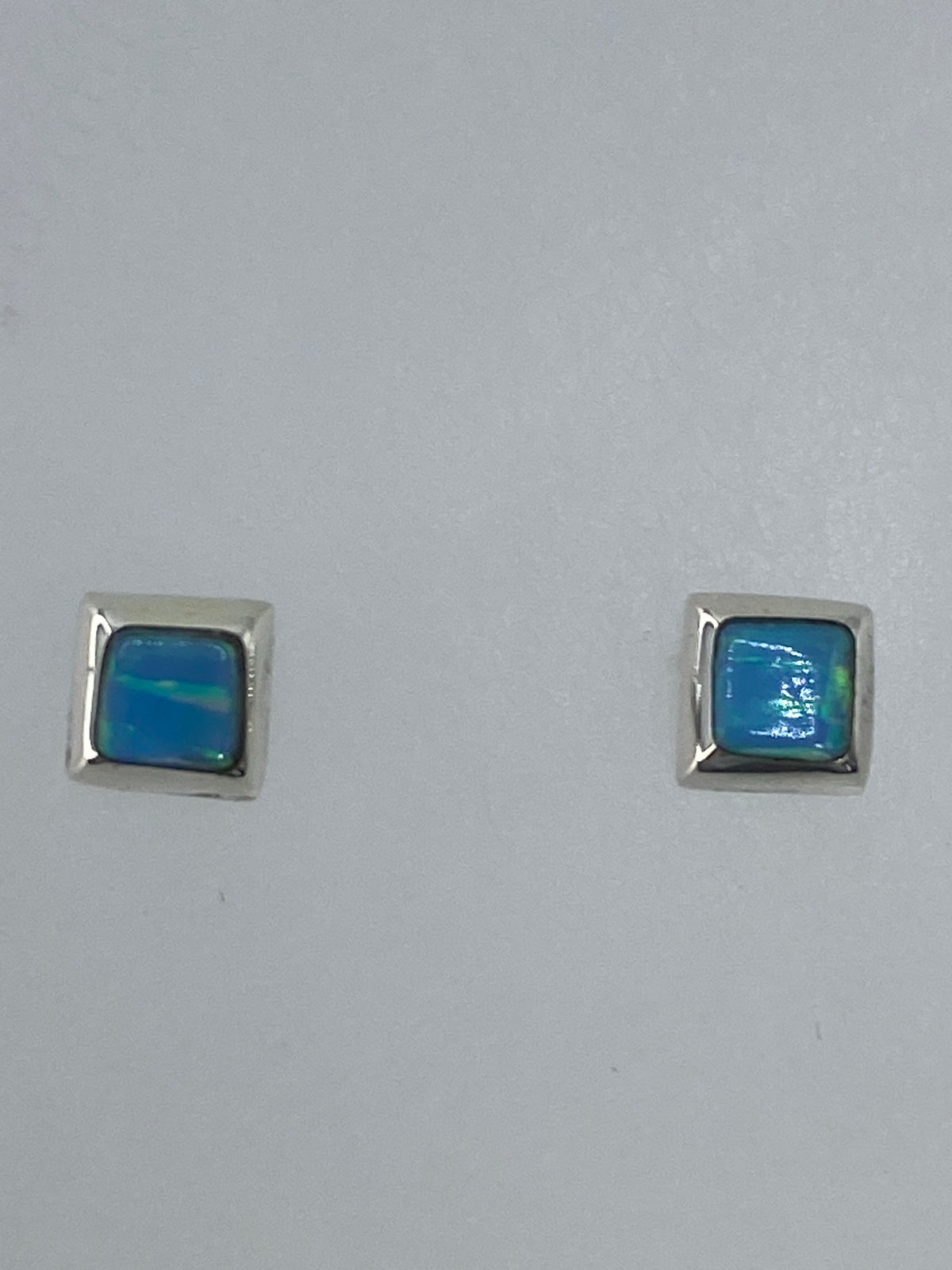 Par de aretes de plata con ópalo de fuego multicolor, detalle frontal